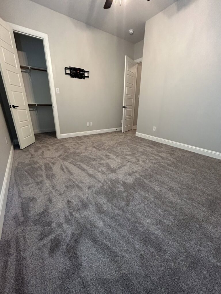 A new dark gray carpet installation in a bedroom by Texas Tuff Floors in Dallas, TX
