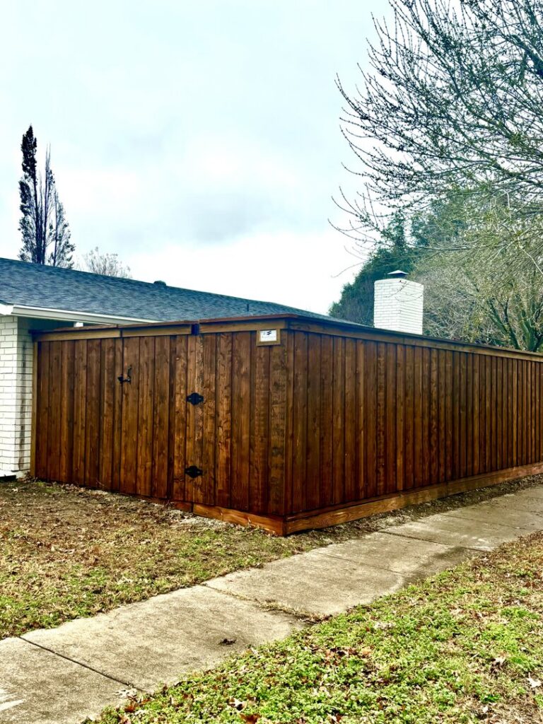 A newly installed dark stained wood privacy fence with a gate by EverFence in Dallas, TX.
