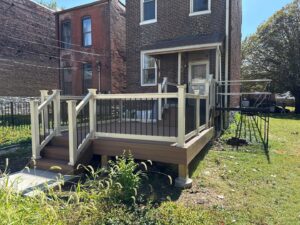 A newly built deck featuring white and black railings with stairs, completed by Chesley Fence & Deck in Fairview Heights, IL.