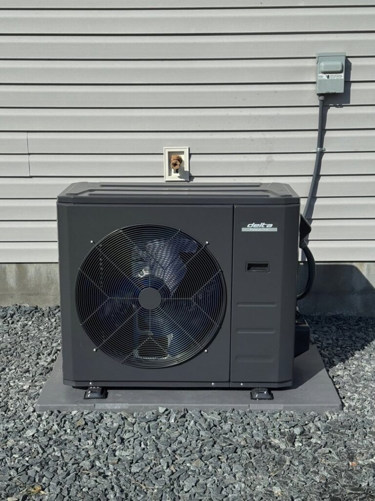 A new Delta outdoor HVAC unit installed on a gravel bed next to a residential building in Wilson, NC.