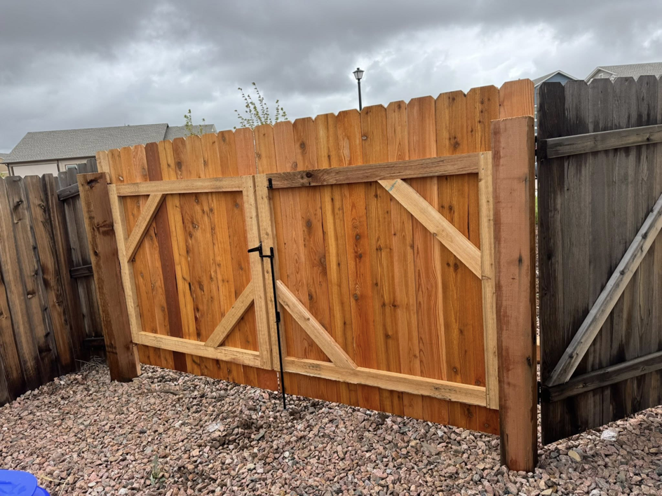 A newly installed double wooden gate with diagonal bracing in an existing fence by Slater Fence Co in Houston, TX.