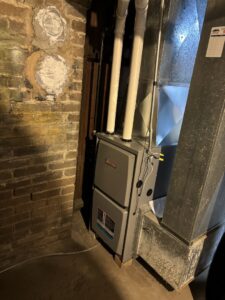 A new Ducane furnace installation next to a brick wall in a basement by Nordic Air Heating & Cooling in West Allis, WI.
