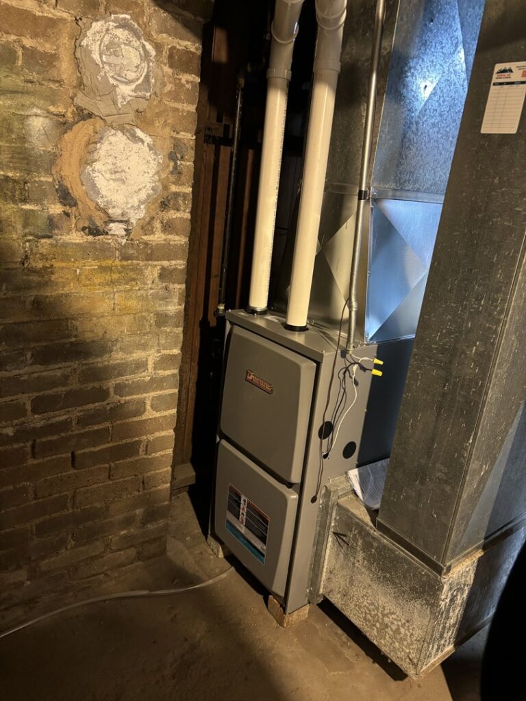 A new Ducane furnace installation next to a brick wall in a basement by Nordic Air Heating & Cooling in West Allis, WI.