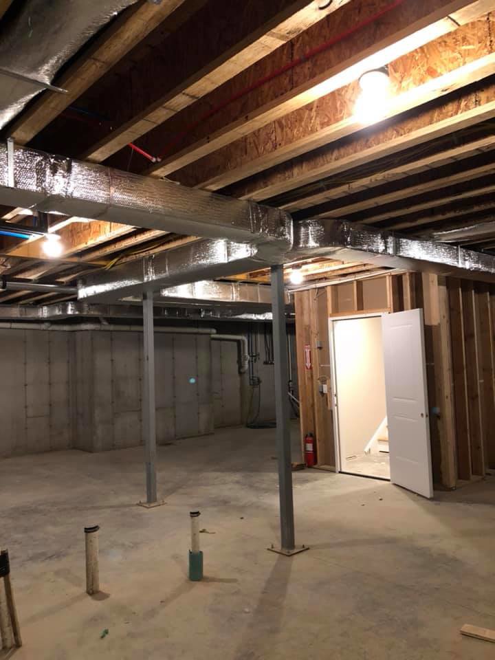 Newly installed ductwork in a basement ceiling by Climate Care Heating & Air Conditioning in Norwalk, CT