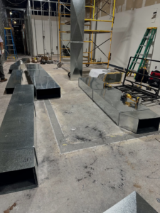 New metal ductwork sections laid out for installation on a construction site by Magic Duct in Baltimore, MD