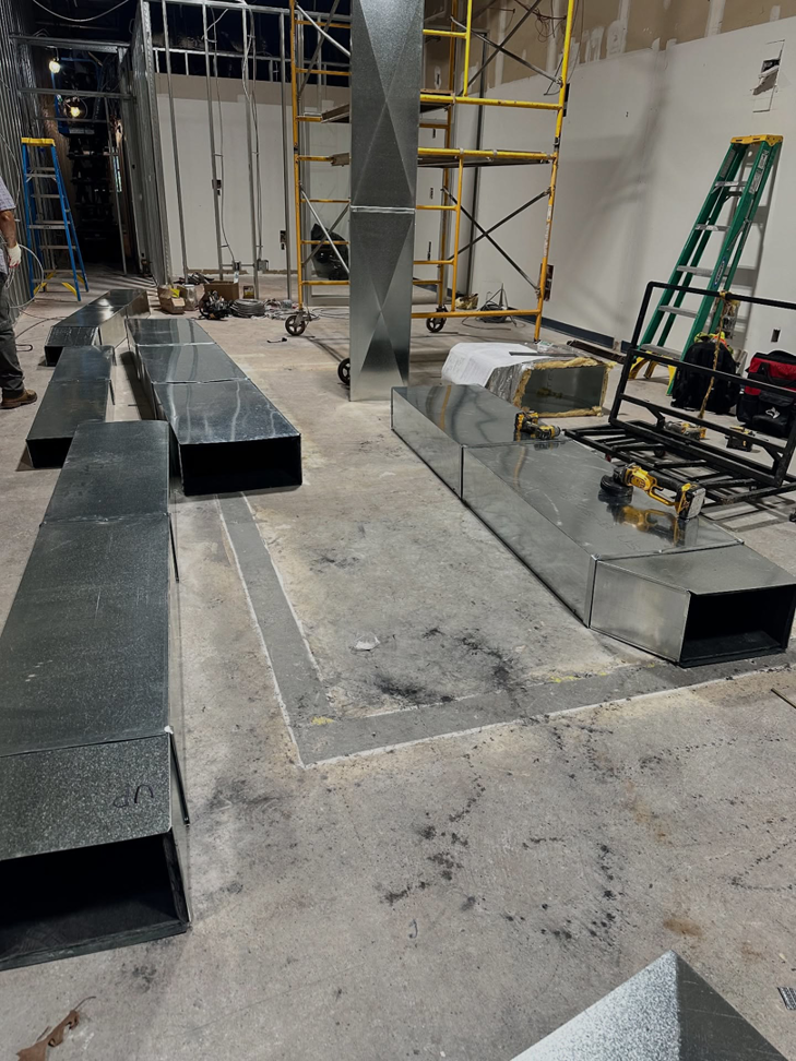 New metal ductwork sections laid out for installation on a construction site by Magic Duct in Baltimore, MD