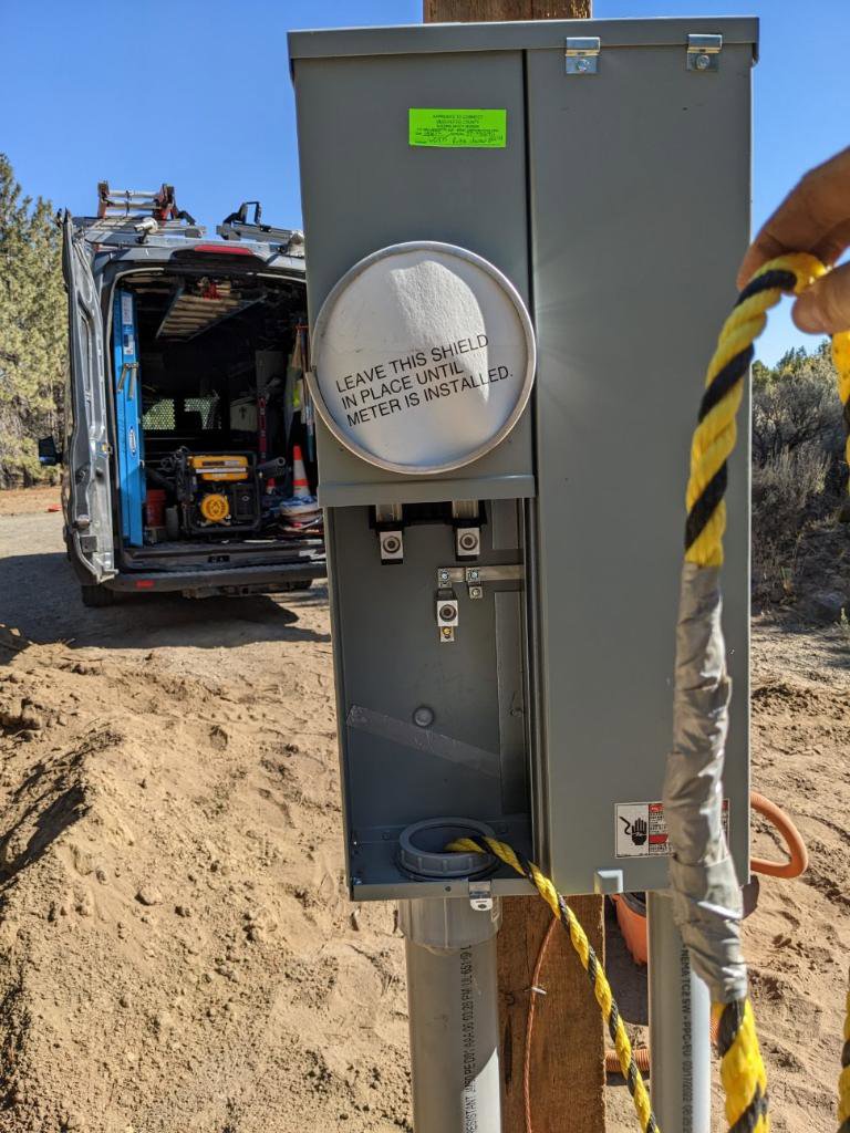 A new electrical meter base being installed with a service van in the background by Gold Electric INC in Bend, OR.