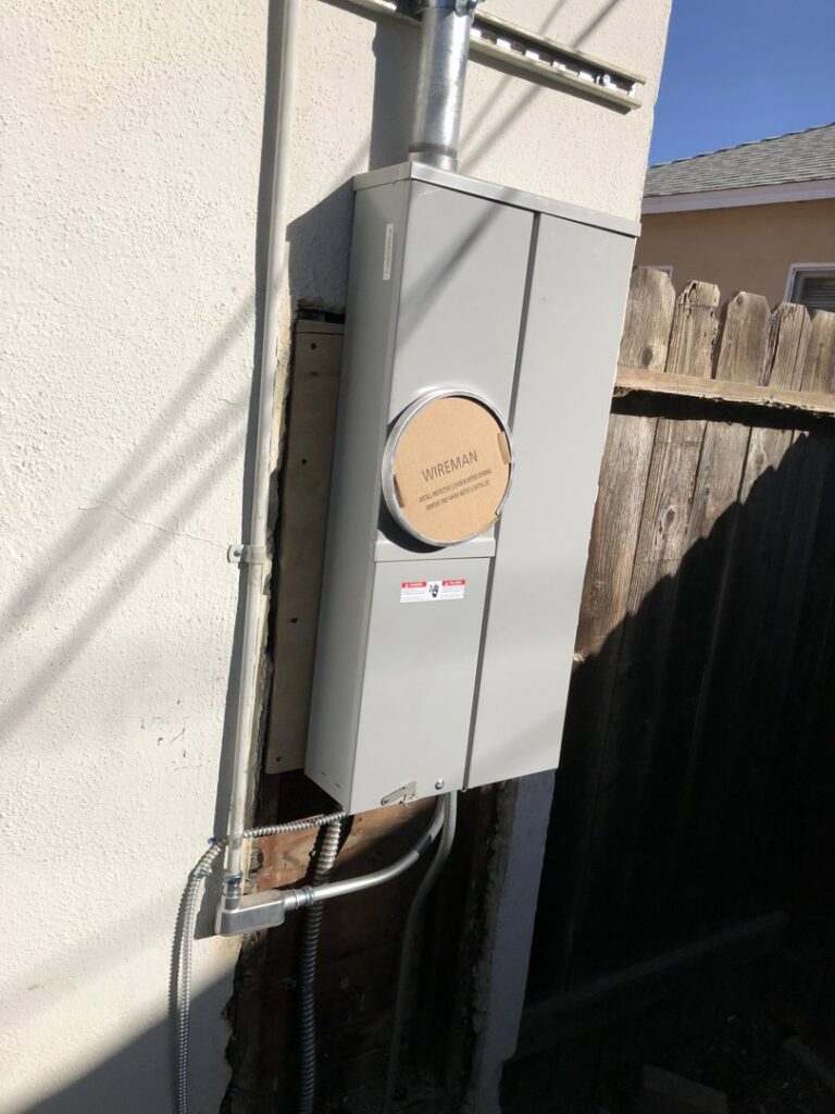 A newly installed electrical meter box and conduit on the exterior of a residential building by Prime Electric in Bellevue, WA.
