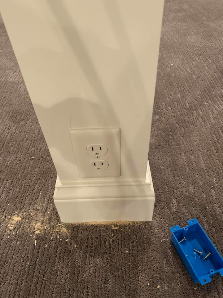A newly installed electrical outlet in a white pillar, with an electrical box nearby, completed by Handy Hollms in Waukesha, WI