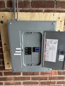 A newly installed electrical panel with its door open on a brick wall by MV Electrical LLC in Phoenix, AZ.