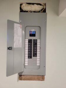A newly installed electrical panel with the door open, showing circuit breakers, by Jeremy Electrical in Roeland Park, KS.