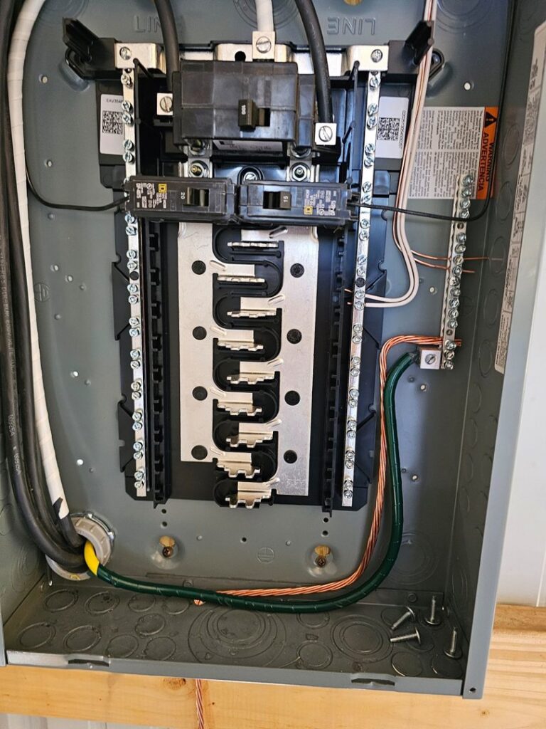A new and neatly wired electrical panel with circuit breakers, expertly installed by Titus & Son's Electric in Bluffton, IN.