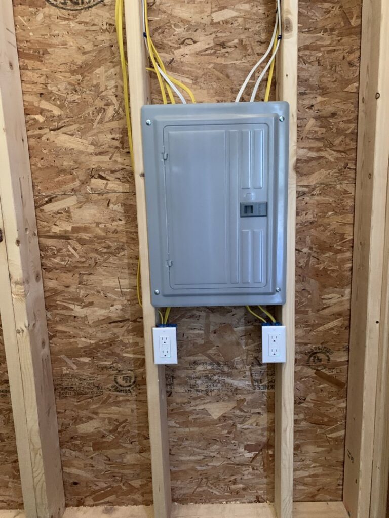 A new electrical panel and outlets during rough-in wiring on an unfinished wall by Building Connections LLC in Auburn, ME.
