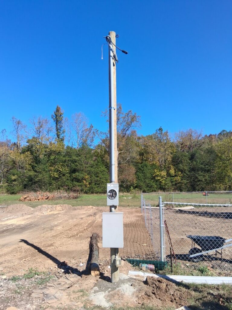 A new electrical pole and meter installation in a field by Elite Electrical TN in Jackson, TN.