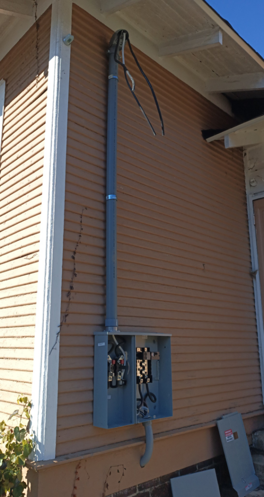 New electrical service panel and conduit installation on the exterior of a house by Elemental Electrical in Chattanooga, TN.