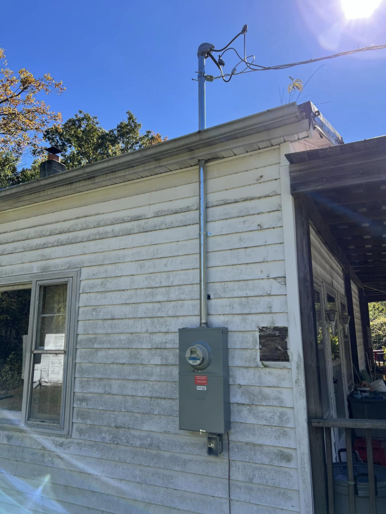 A newly installed electrical service panel and conduit on the side of a house, demonstrating an upgrade by RJ Boyd Electric in Christiansburg, VA.