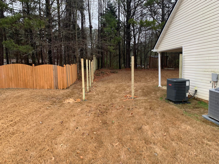 Newly installed wooden fence posts in a backyard, indicating a new fence project by ETJ Fence and Restoration, INC. in Atlanta, GA.