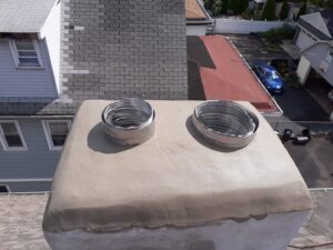 Two new flexible metal chimney liners installed at the top of a chimney, showcasing work by Colombus Chimney in Elizabeth, NJ.
