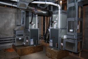 New furnace and air handler units with ductwork installed in a utility room by Chapman Air and Heat in Dallas, TX
