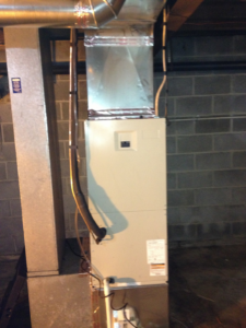 A newly installed furnace or air handler unit with connected ductwork in a basement by L & R Electrical and HVAC Services in San Marcos, CA.