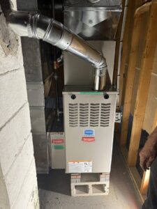 A newly installed furnace and air handler unit in a basement by Nimmer Heating & Air Conditioning in Milwaukee, WI.