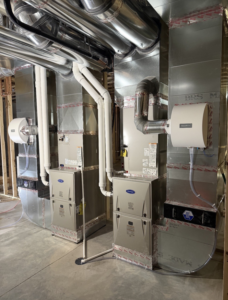 Newly installed furnaces and ductwork in a residential basement by Ideal Heating & Air Conditioning in Omaha, NE.