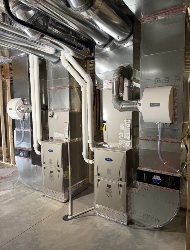 Newly installed furnaces and ductwork in a residential basement by Ideal Heating & Air Conditioning in Omaha, NE.