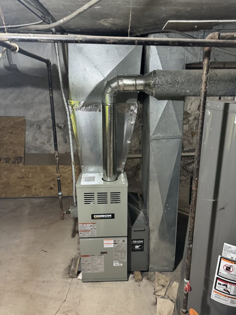 A newly installed furnace and ductwork in a basement by Ferreira Mechanical, LLC in Fall River, MA