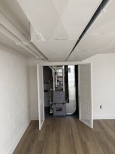 A newly installed furnace and ductwork system in a utility closet by Omega Air Solutions in West Des Moines, IA.