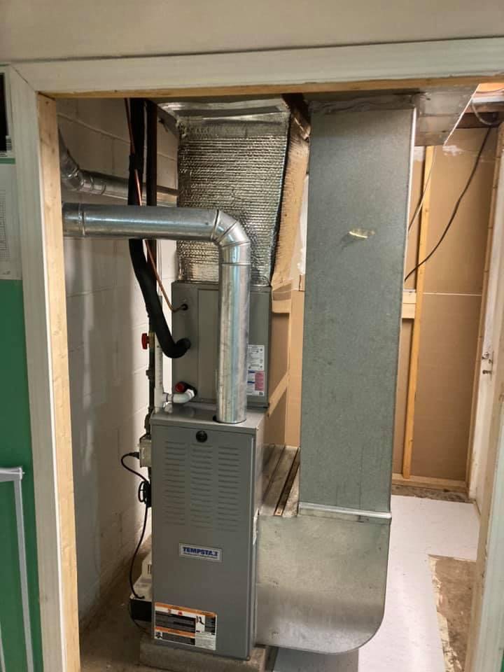 A new furnace installation in a utility closet with ductwork by Manny Services in Syracuse, NY.