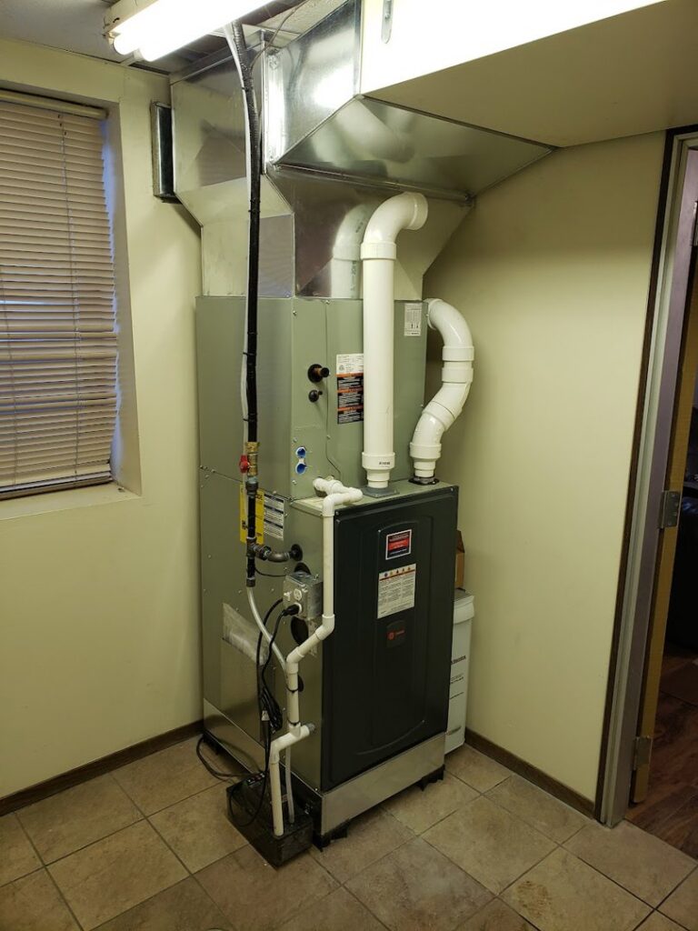 A new furnace and air handler unit with ductwork and gas lines installed in a utility room by Northern Peak Heating & Cooling in Bozeman, MT.