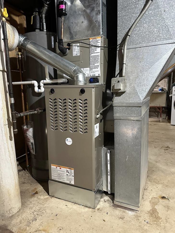 A new furnace installed next to a water heater by F&S Heating And Cooling in Elgin, IL.