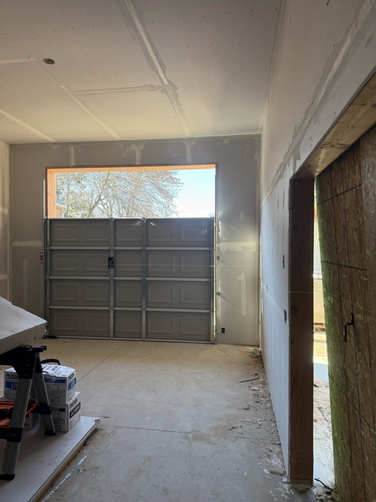 A newly installed garage door inside a residential garage under construction by Rhino Garage Doors LLC OKC in Edmond, OK.