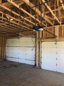 Two new garage doors and openers installed in a garage under construction by Colorado Garage Door Guy in Aurora, CO.
