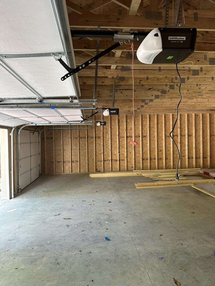 A newly installed white garage door and LiftMaster opener in a residential garage by Up Garage Door in Nashville, TN.
