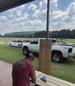 A hand holding a box of new garage door rollers, representing quality parts used by Cajun Doors & More in Lafayette, LA.