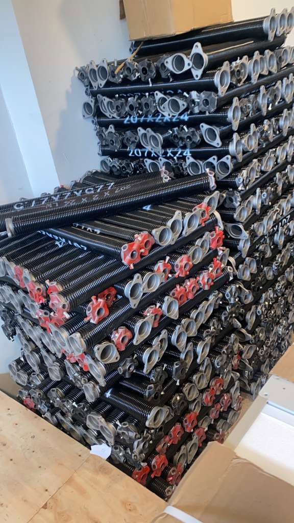 A stack of new garage door torsion springs, ready for installation or replacement by BSD Garage Door Service in Naperville, IL.