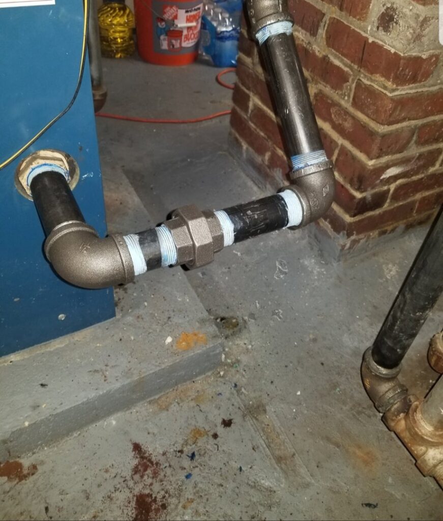 Newly installed black iron gas piping connected to a blue boiler by Batista Heating & Cooling, LLC in Charlotte, NC.