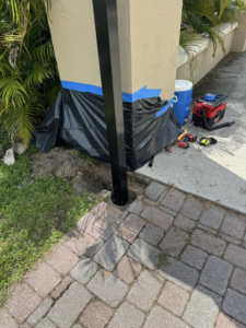 A new gate post being installed into the ground by Big Bear Automatic Gates, LLC in La Belle, FL.