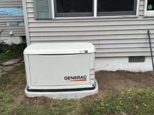A newly installed Generac generator on a concrete pad next to a house by Great Lakes Power Generation in Williamsburg, MI.