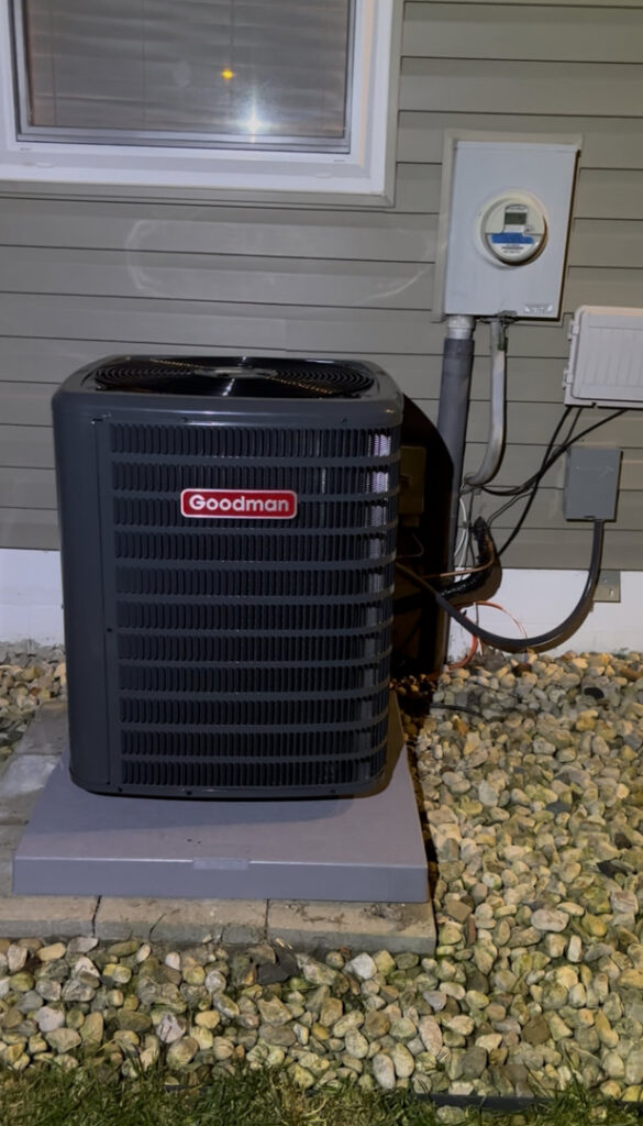 A new Goodman outdoor AC unit installed on a concrete pad with gravel landscaping by Buckeye Mechanical Construction in Columbus, OH.