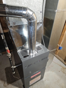 A newly installed Goodman furnace with connected ductwork and flue pipe by HVAC and Appliances repair LLC in Arlington, VA.