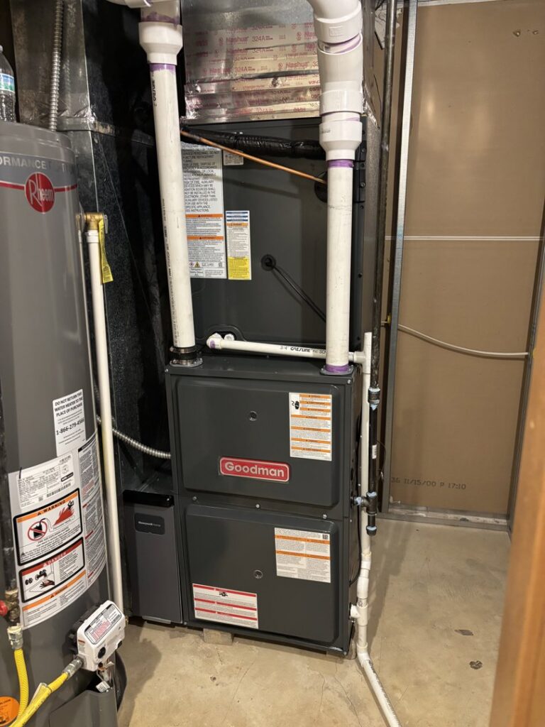 A new Goodman furnace and water heater installed in a utility room by Buckeye Mechanical Construction in Columbus, OH.