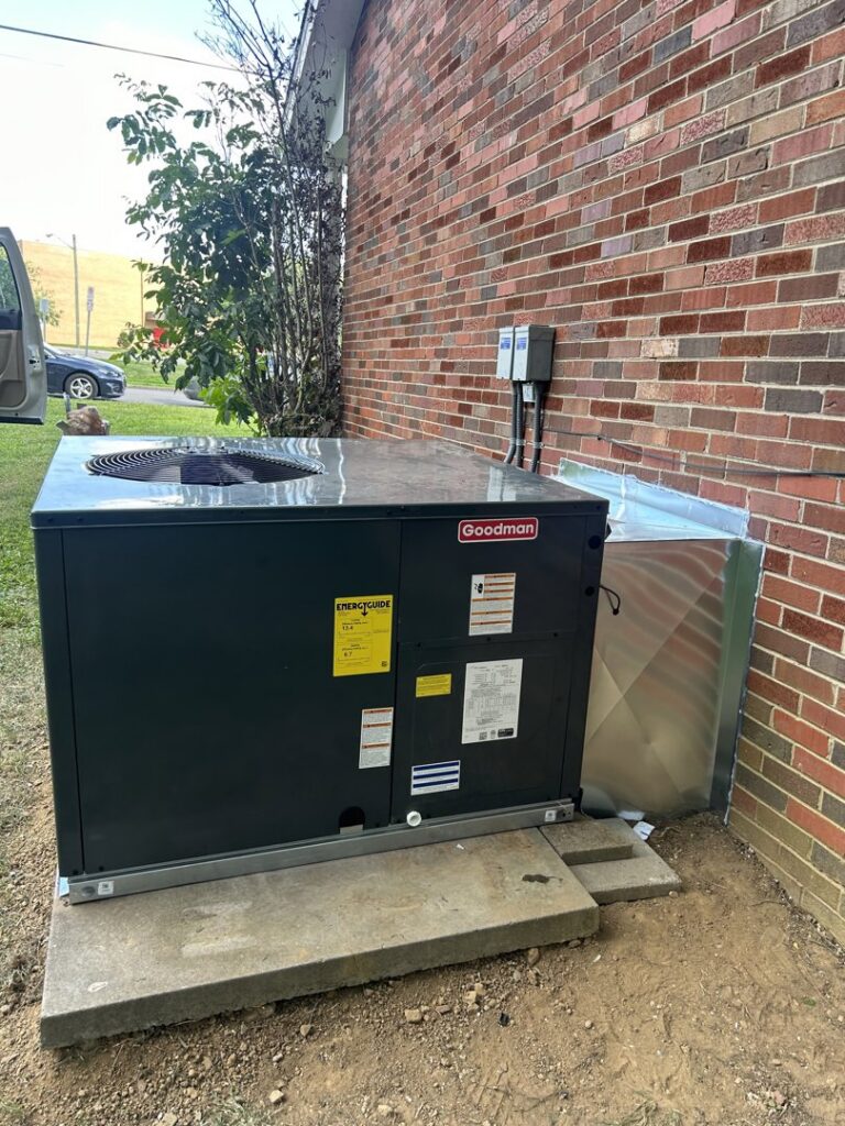 A new Goodman outdoor HVAC unit installed next to a brick house by Comfort Zone Mechanical in Antioch, TN.