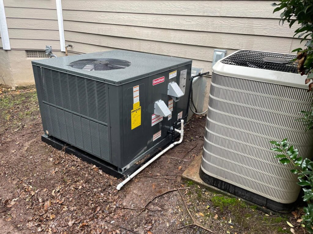 A newly installed Goodman outdoor HVAC unit next to an older unit by Luciano's Air Services in Durham, NC.