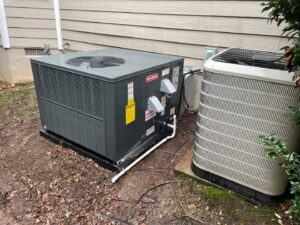 A newly installed Goodman outdoor HVAC unit next to an older unit by Luciano's Air Services in Durham, NC.