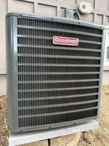 A newly installed Goodman outdoor air conditioning unit next to a residential building by Dad's Heating and Cooling in Blue Springs, MO.