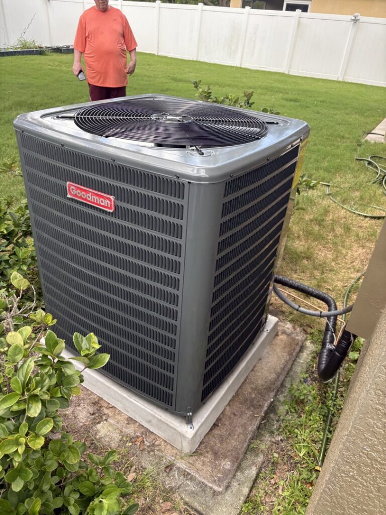 A newly installed Goodman outdoor AC unit in a residential backyard by Timely Air Conditioning in Riverview, FL.