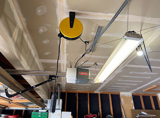 Two newly installed gray and white garage doors on a new construction home by CHS Garage Repair of Seattle, WA.