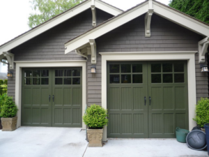 Two newly installed green garage doors on a house by Discount Garage Door Company in Spokane, WA.